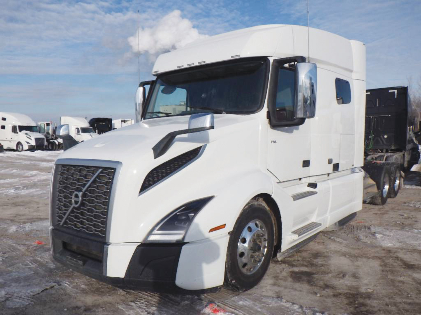 Volvo VNL 740 conventional sleeper truck in white, front-left view showing cab and grille with large bumper, side mirrors, and sleeper compartment.