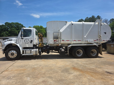 Freightliner M2 garbage truck side view showing cab and large white refuse body with dual rear axles.