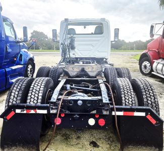 Truck chassis rear view showing dual rear axles, fifth-wheel area, and dual mud flaps.