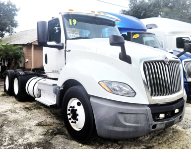 White International LT625 daycab tractor showing front grille and cab, with 2019 tag on windshield and side mirror.