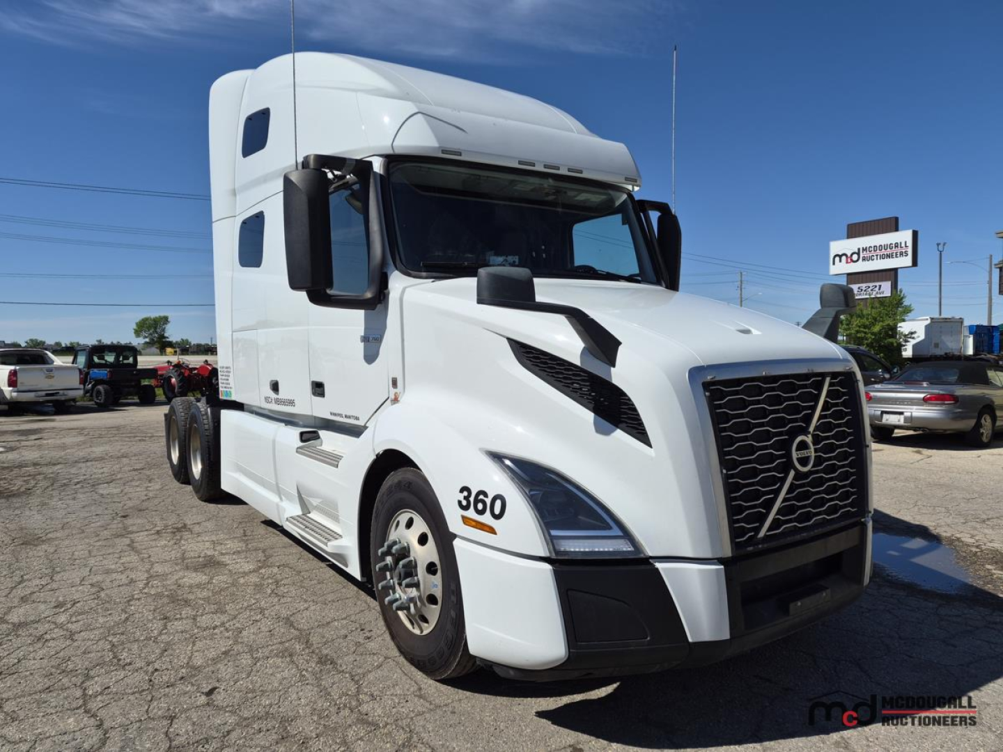 Truck cab exterior showing Volvo VNL760 Day Cab, white with 360 decal, large black grille, aerodynamic mirrors, three-quarter front view.