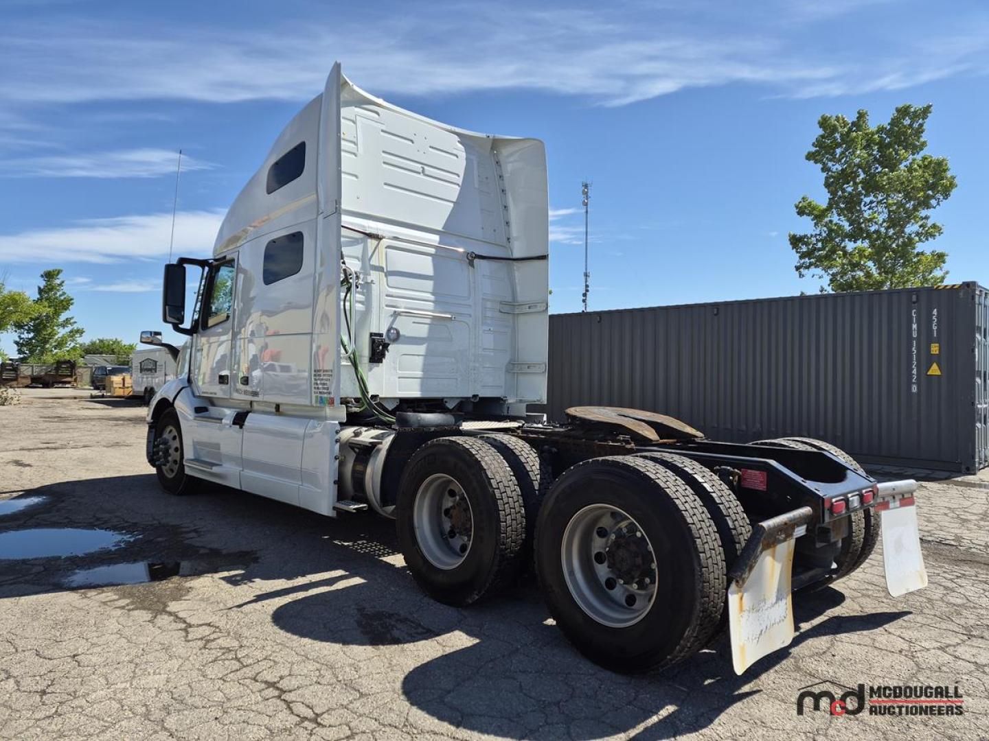 Volvo VNL760 day cab tractor from rear-left showing sleeper, dual rear axles, and white exterior with chrome mirrors.