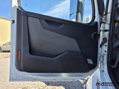 Volvo VNL760 truck cab interior door panel view with black plastic and speaker grill.