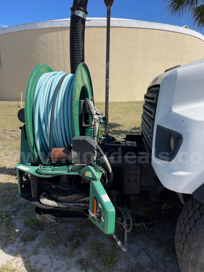 Freightliner vacuum truck front with hose reel attachment and cab visible