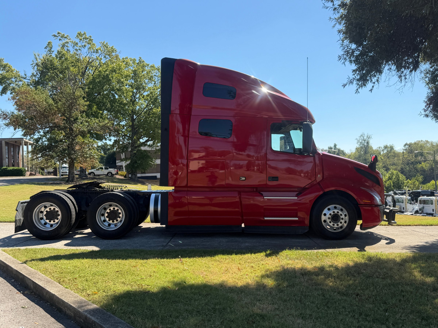Volvo VNL64T760 sleeper cab in side profile showing red tractor with twin rear axles.