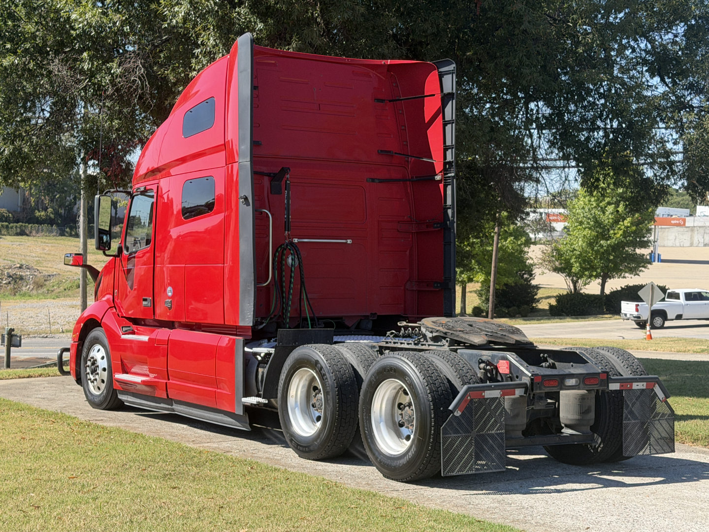 Volvo VNL64T760 sleeper tractor in red with rear view showing fifth wheel area and dual rear axles.