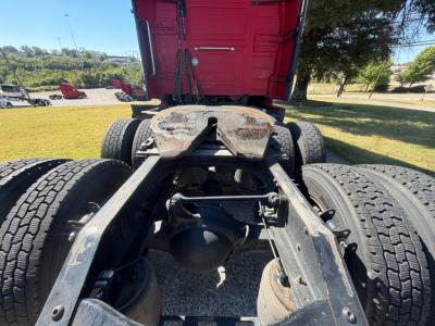 Volvo engine bay showing rear chassis with fifth wheel and dual rear axles; visible components include the mid-frame, drive axle differential housing, leaf springs, and tires.