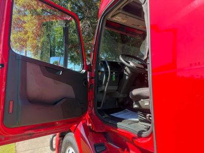 Volvo VNL64T760 truck interior view from open driver door showing steering wheel, dashboard, and entry step.