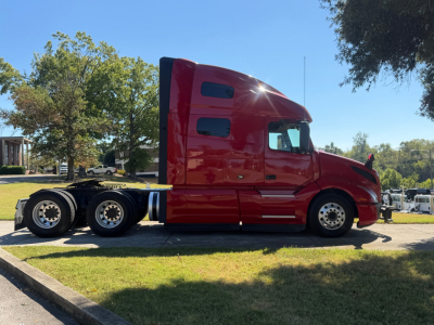Volvo VNL64T760 sleeper cab in side profile showing red tractor with twin rear axles.