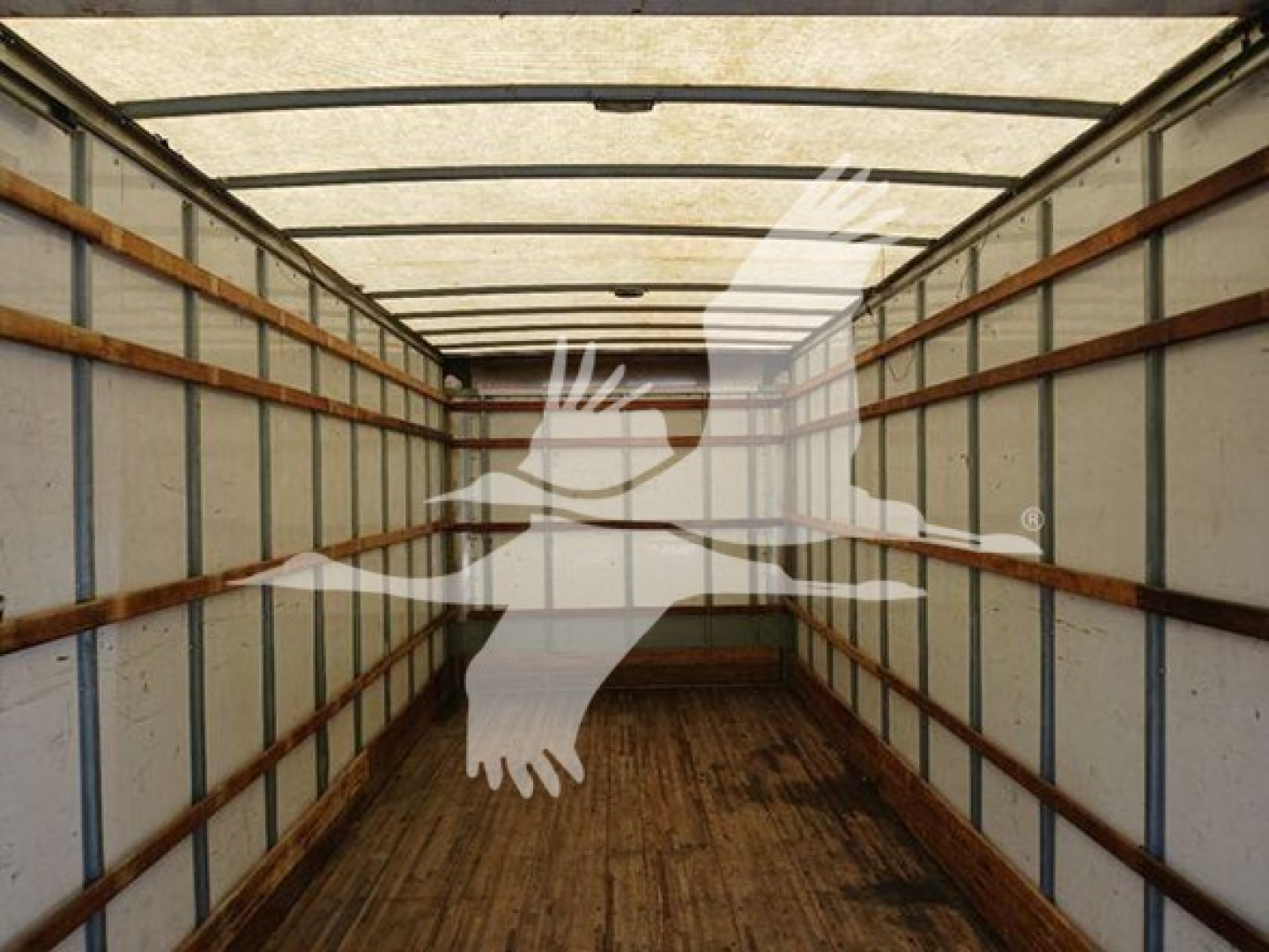 Box truck cargo area showing empty interior with wooden floor and side rails, faded light through roof, watermark overlay.
