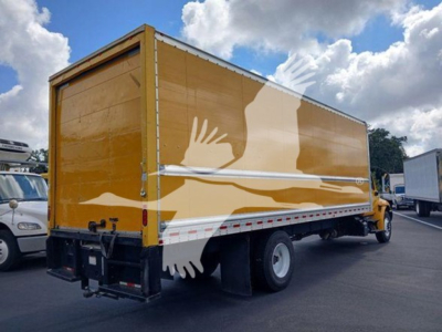 Truck bed side showing box truck with yellow cargo body and graphic artwork of birds in flight.