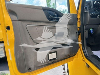 Truck interior door panel view of a 2020 International MV with yellow exterior, showing door pocket and control panel.