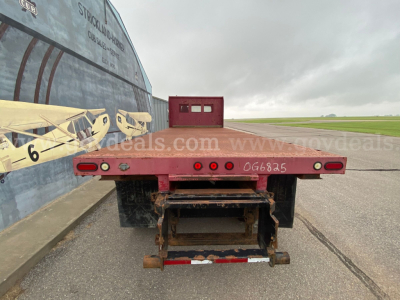 Flatbed rear view of a 2016 Freightliner M2 106 truck showing a red flatbed with taillights, bumper, and rear hitch; stock number 32008-1 not visible in this shot.