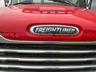 Front view of a red 2016 Freightliner M2 106 with chrome grille and emblem, hood reflection visible.