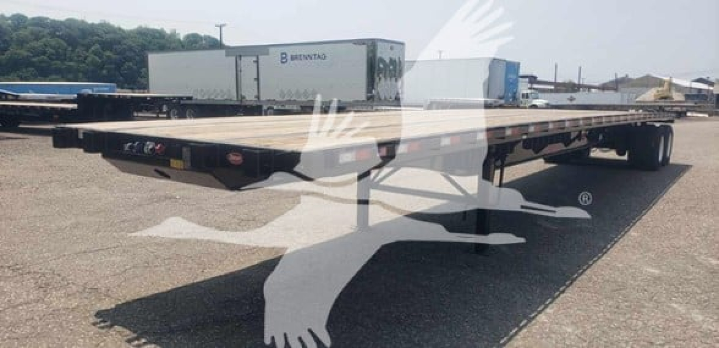 Flatbed trailer with air sliding tandem, Dorsey Steel 2026, shown in yard with other trailers.