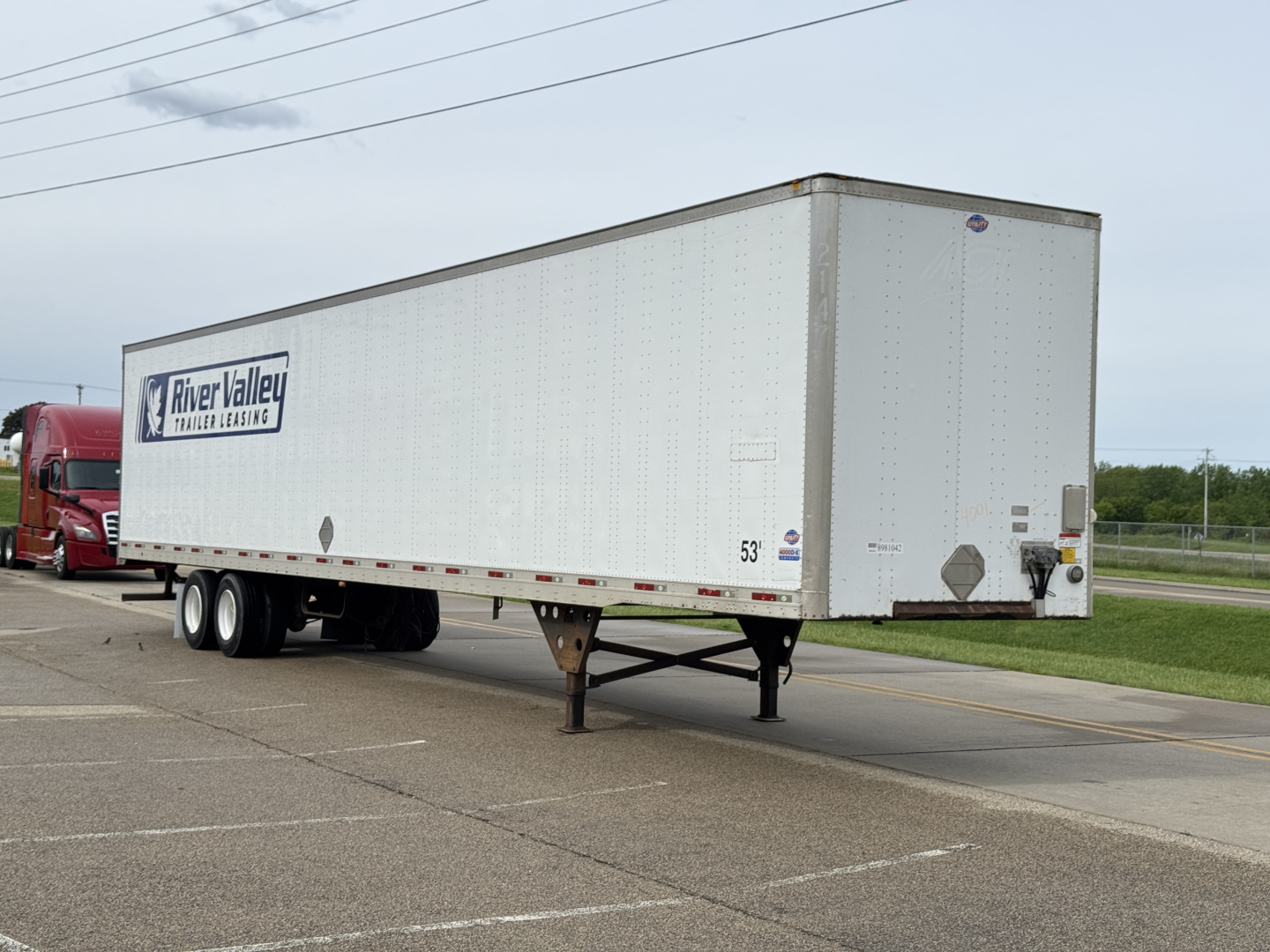 Utility trailer showing River Valley trailer leasing logo and 53" height with tandem axles in a lot