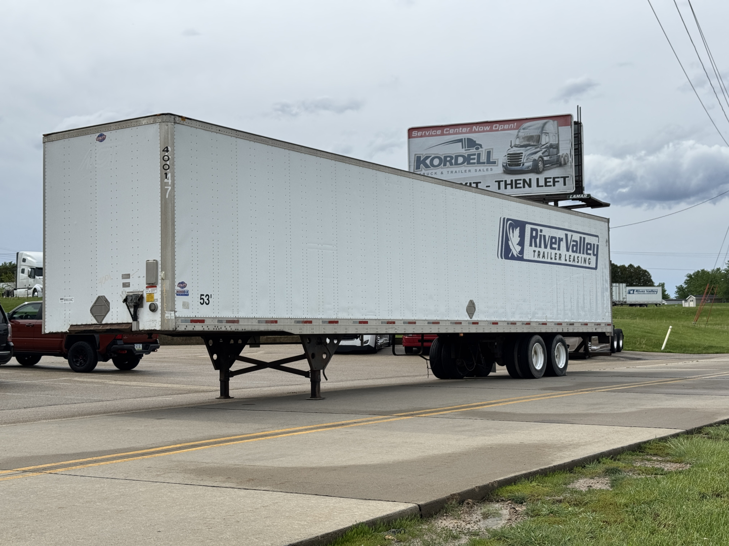 Trailer showing River Valley trailers graphic, Utility 4000DX box trailer with landing gear and dual rear axles, side markings including 53' length and model number.