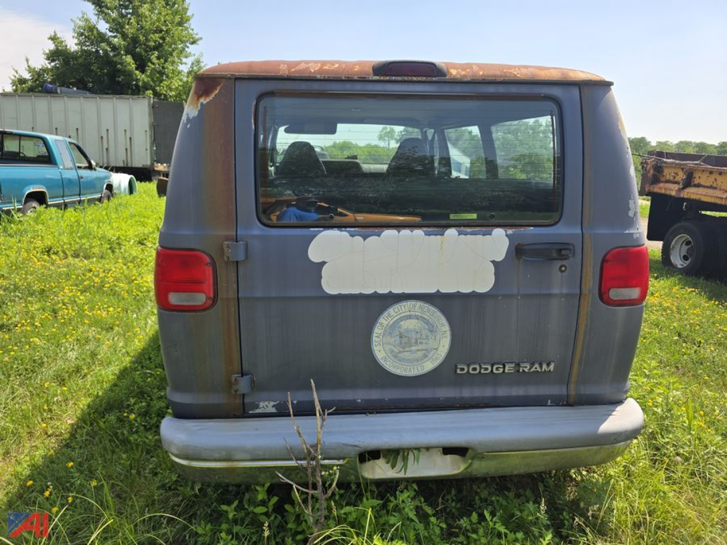Back of a 1994 Dodge Ram full-size van with faded paint, rear window, and Dodge Ram emblem visible.