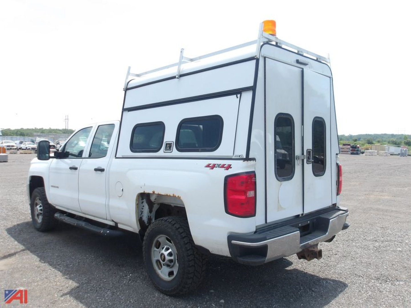 Chevrolet Silverado 2500HD Quad Cab pickup with cap, rear and passenger-side views, white long-bed crew cab, 4x4 badge, utility ladder rack, cab-over cap with dual doors