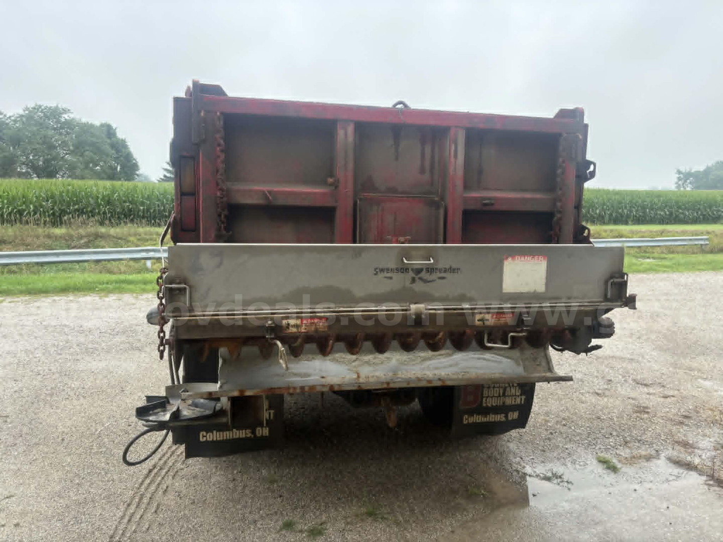 Dump truck bed and hitch area of a used 2000 International 4900 with dump box, rear view showing red cargo bed and silver tailgate.
