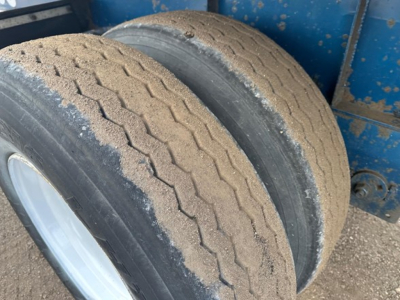 Great Dane Freedom LT trailer wheel well showing dual rear tires with tread wear and sand/dust on tires.