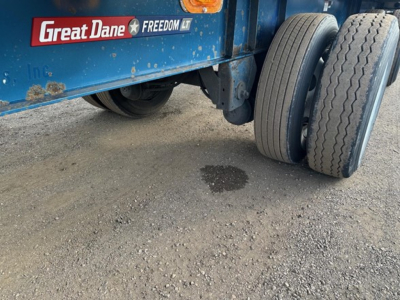 Great Dane Freedom LT trailer wheel area showing dual rear tires and blue painted frame with Great Dane Freedom LT logo and sticker.