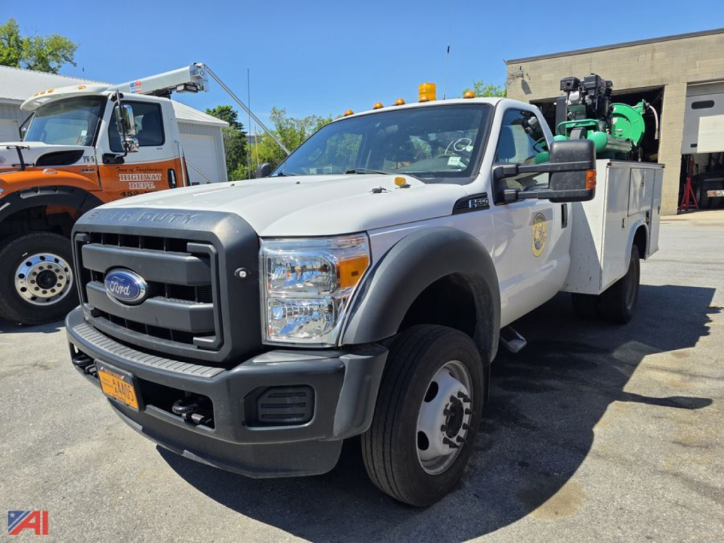 Ford F-550 Super Duty utility truck in service use showing front grille and utility bed with crane equipment