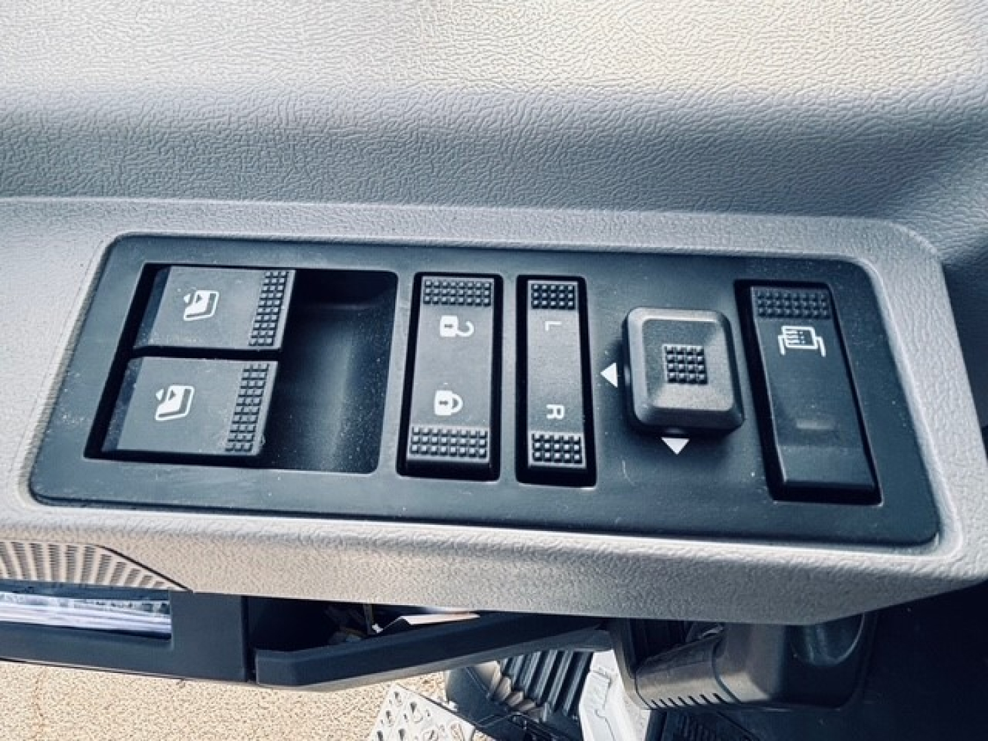 Truck interior switch panel showing window controls and mirror adjustment on Mack MD6 cab