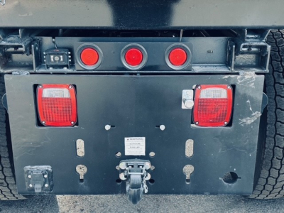 Mack MD6 chassis rear showing taillights, hitch, and rear access panel with red circular lights.