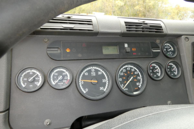 Dashboard of a Freightliner Cascadia 125 day cab showing gauges and digital displays.