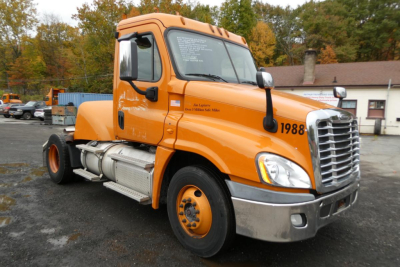 Orange 2013 Freightliner Cascadia 125 daycab truck side view showing cab, fuel tanks, chrome bumper, and number 1988 on door.