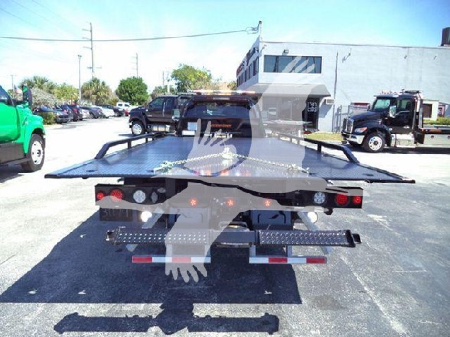 Ram 5500 rollback tow truck flatbed rear view showing hydraulic ramps and taillights.
