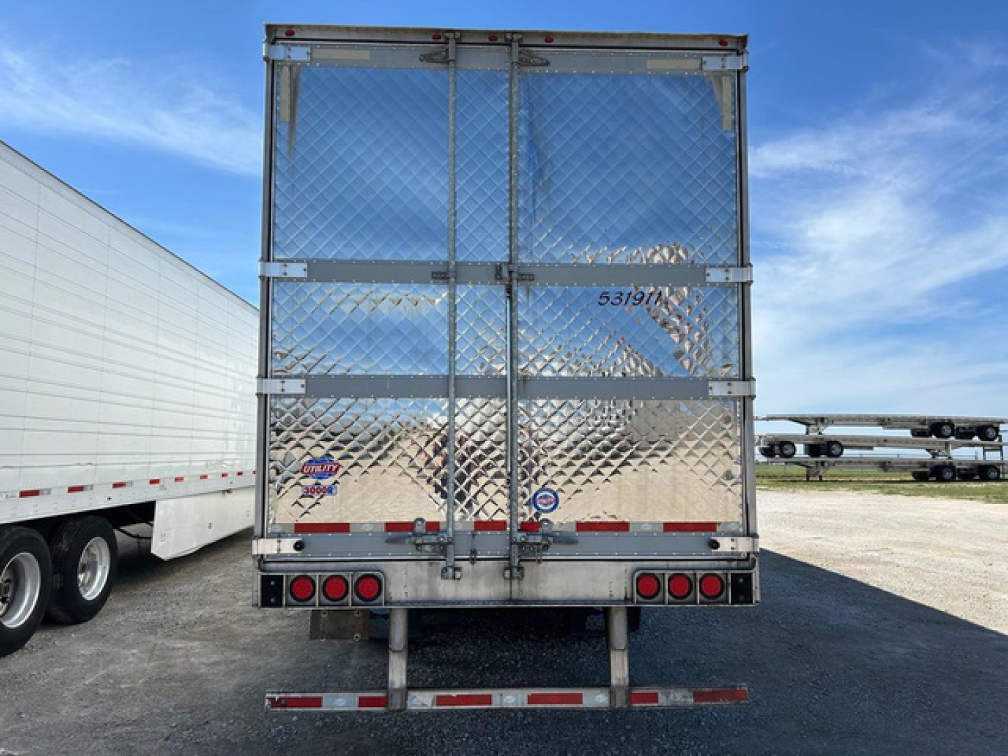 Refrigerated trailer rear view showing diamond plate doors and taillights.
