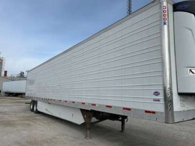 Reefer trailer side view showing white refrigerated 2019 Utility trailer with landing gear and reflective tape