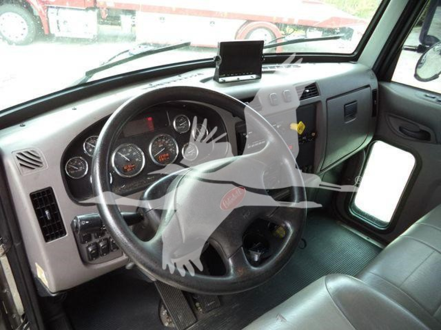 Truck cab interior of a 2021 Peterbilt 337 rolling dashboard with steering wheel and instrument cluster visible.