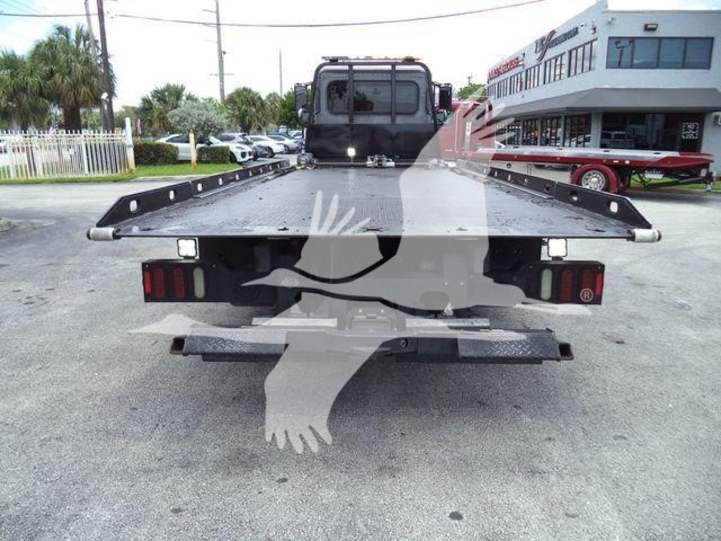 Rear view of a 2021 Peterbilt 337 rollback truck showing flatbed with lights and bumper.