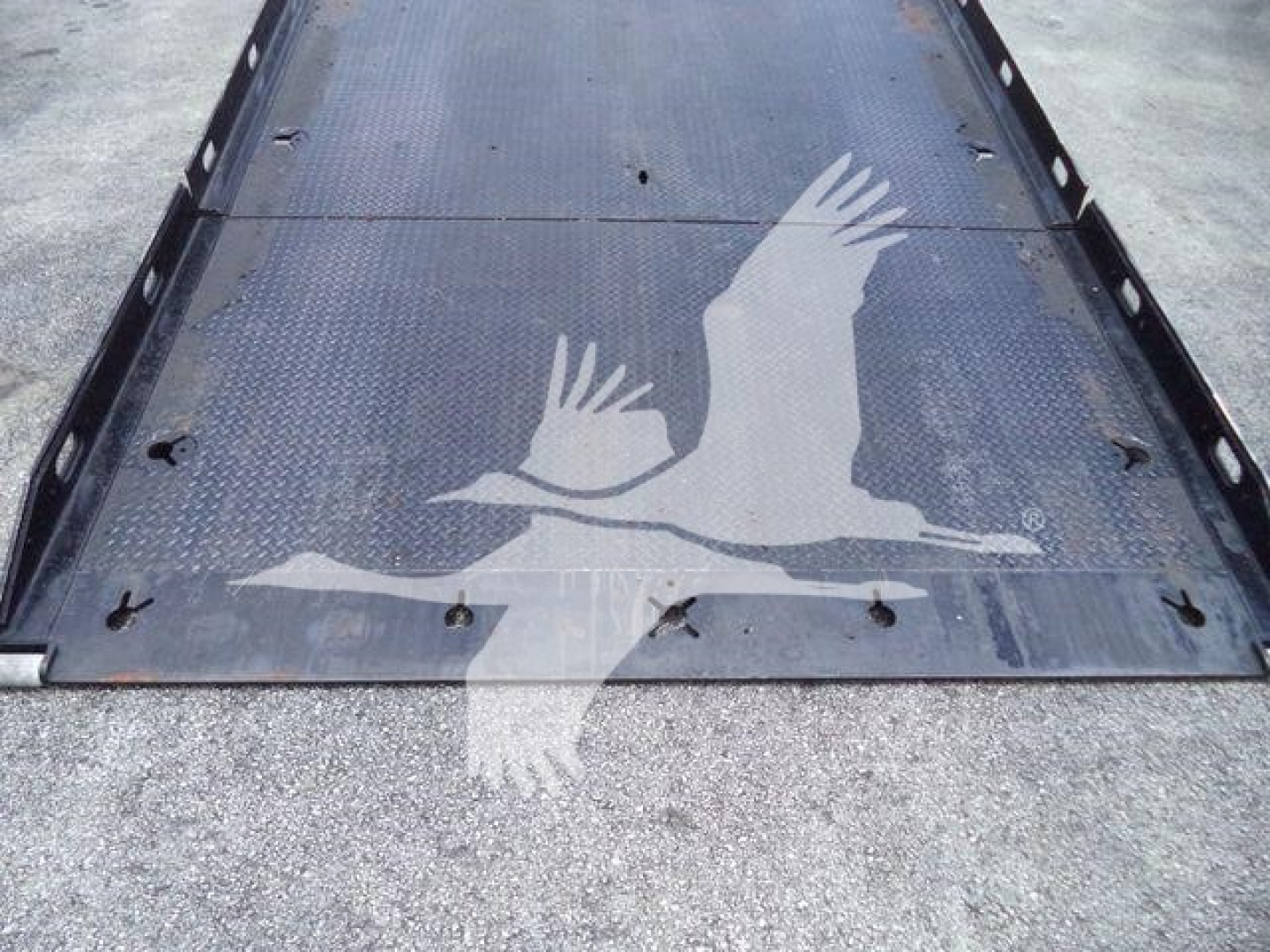 Truck flatbed image showing a Peterbilt rollback with a graphic of a bird in flight on the metal surface; no legible model text visible.