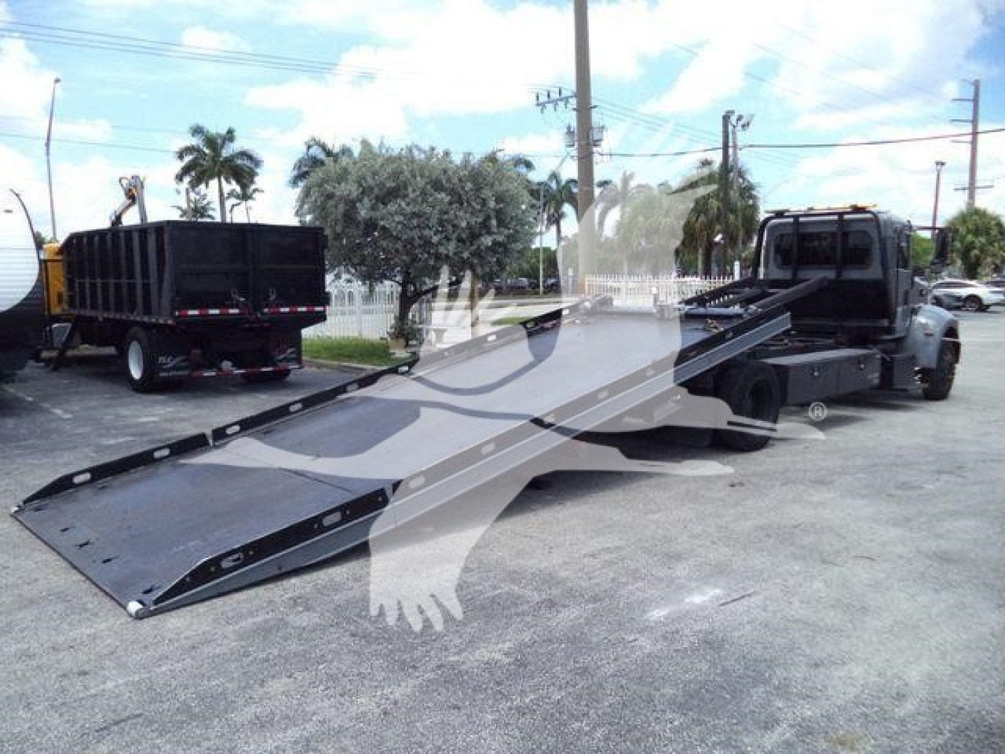2021 Peterbilt 337 rollback truck with long flatbed/wheel-lift ramps extended, black and gray color, VIN 2NP2HM6XXMM759575 visible on listing, stock number T59575.