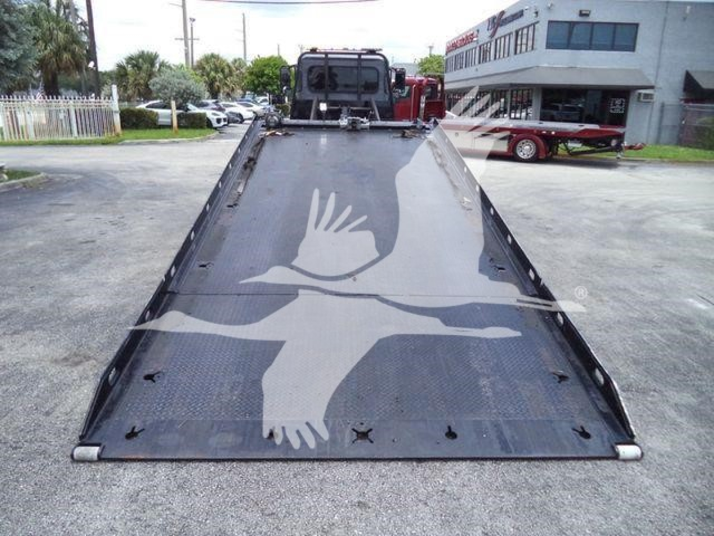 Peterbilt 337 rollback truck bed/viewed from rear with hydraulic tilt bed and a white bird graphic on black surface.