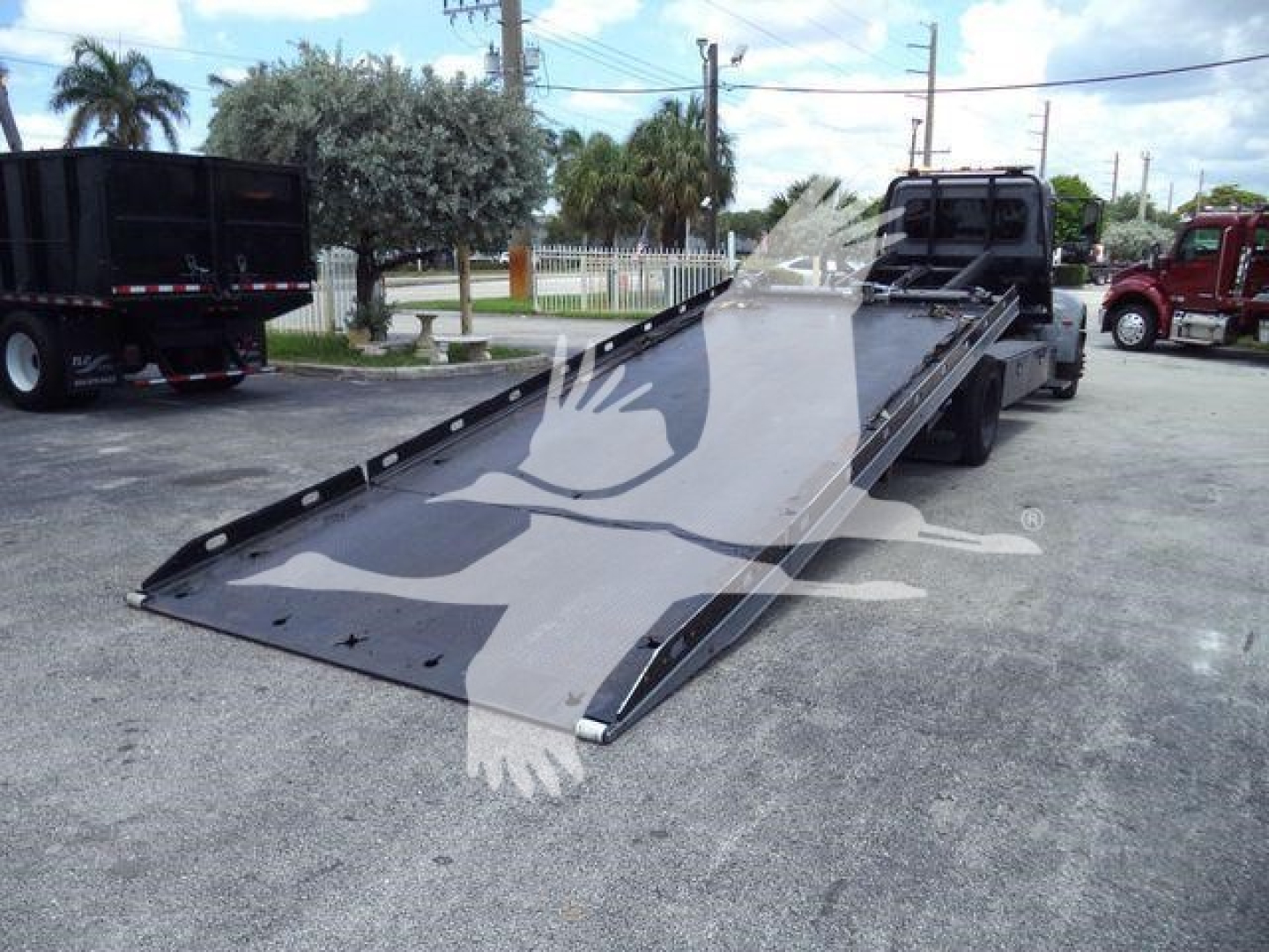 Peterbilt 337 rollback truck with a tilted flatbed ramp and cab visible, VIN tag not legible.