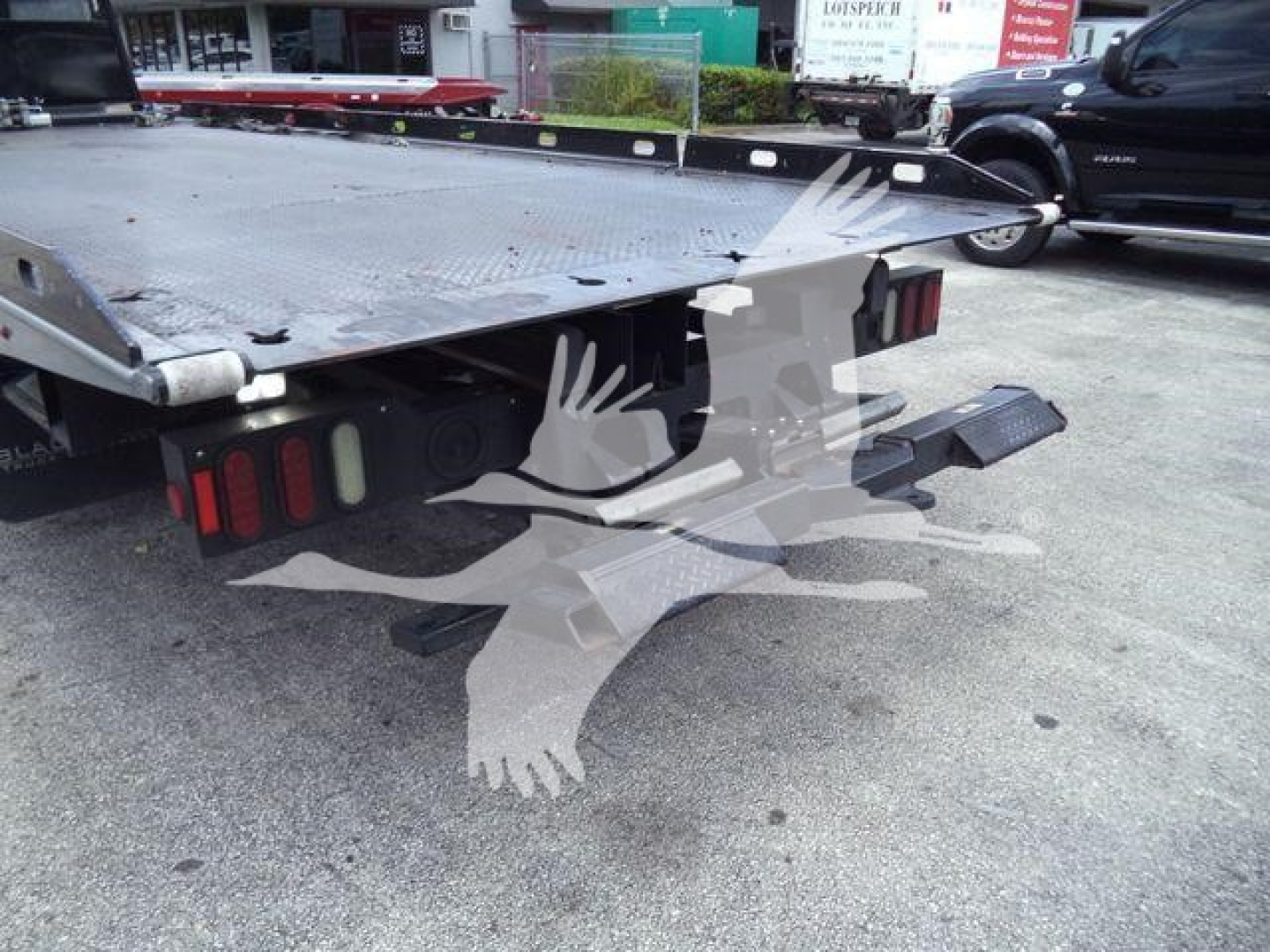 Peterbilt 337 rollback flatbed truck rear view showing steel deck, wheel wells, taillights, and ramps.