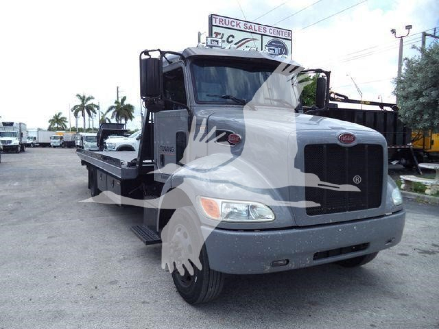 Peterbilt 337 rollback truck front-left view showing cab and flatbed with VIN 2NP2HM6XXMM759575 and stock number T59575.