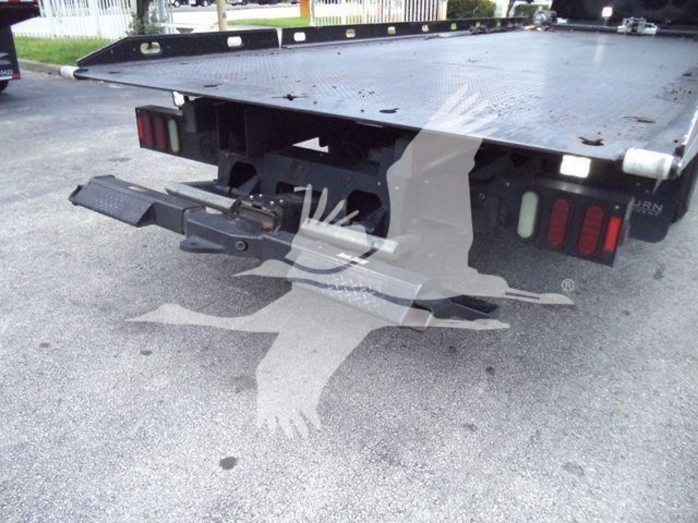 Peterbilt 337 rollback truck rear showing bumper, lights, and towing hitch with flatbed underside.