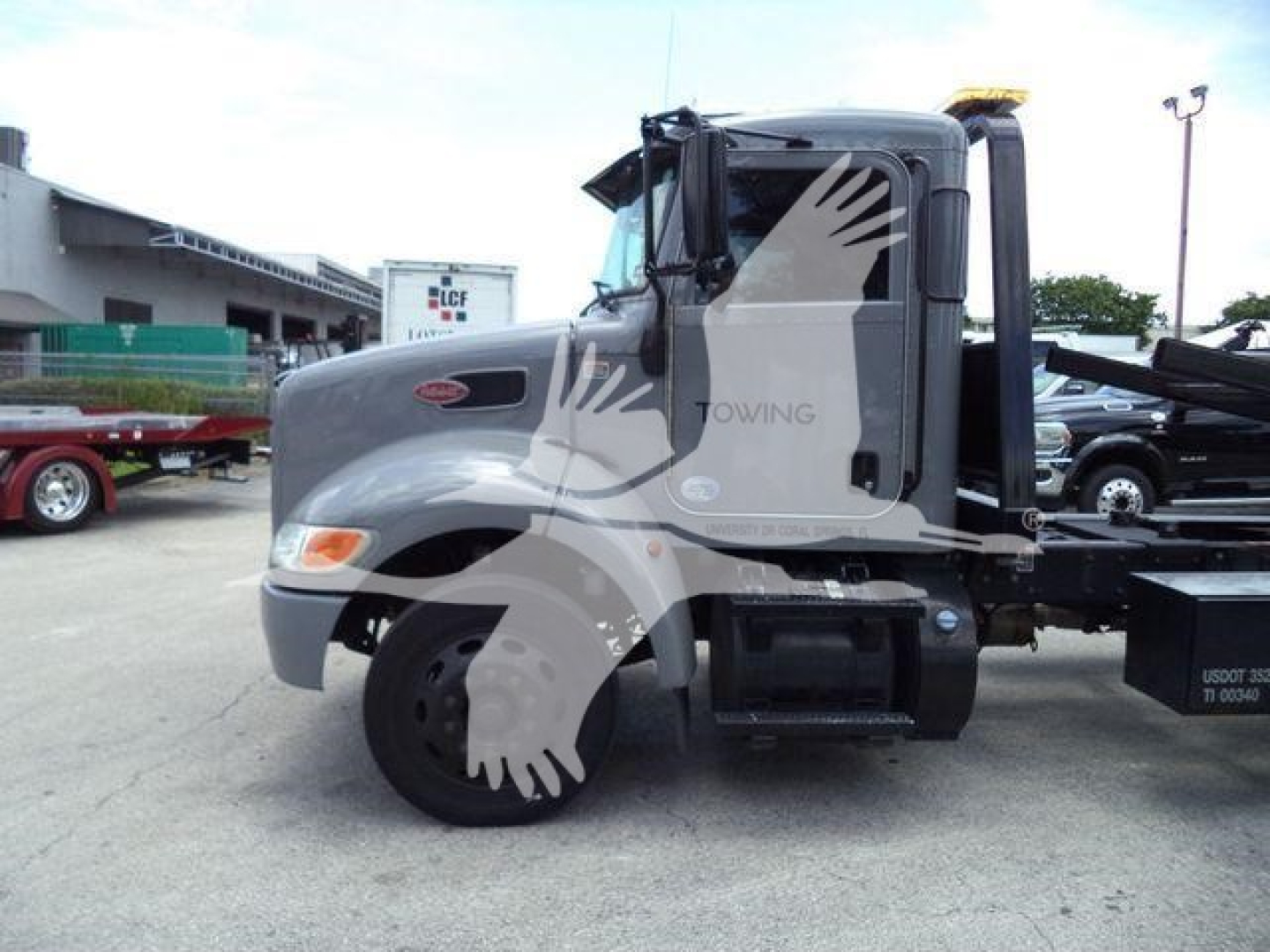 Peterbilt 337 rollback truck side view showing cab, wheel and hydraulic rollback bed.