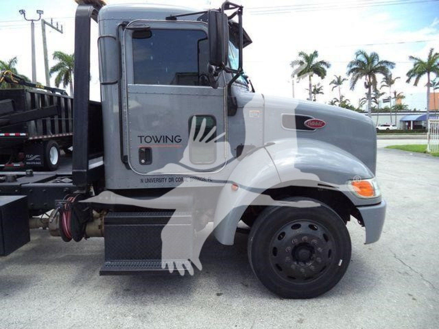 Peterbilt 337 rollback truck side view showing cab, front wheel, and towing equipment with 'TOWING' text on door.