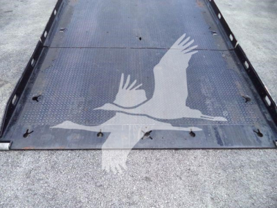 Truck flatbed image showing a Peterbilt rollback with a graphic of a bird in flight on the metal surface; no legible model text visible.
