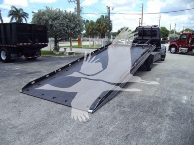 Peterbilt 337 rollback truck with a tilted flatbed ramp and cab visible, VIN tag not legible.