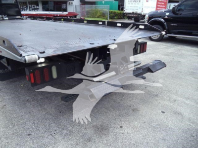 Peterbilt 337 rollback flatbed truck rear view showing steel deck, wheel wells, taillights, and ramps.