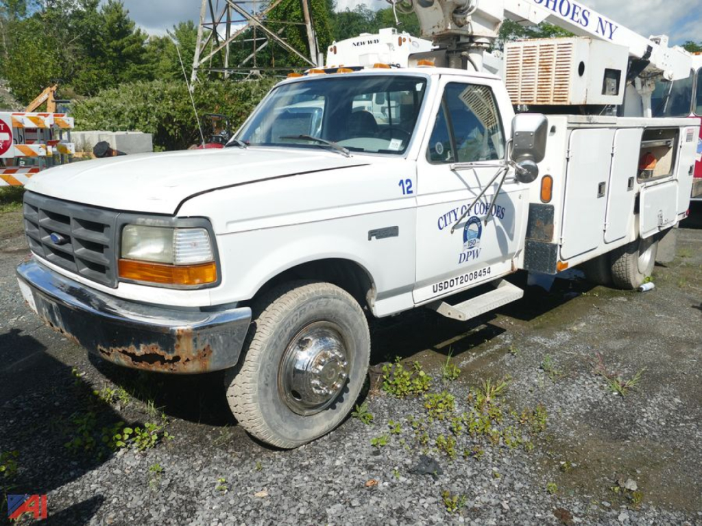 Ford F-Super Duty cab and chassis utility truck showing front grille and service compartments with DPW markings.