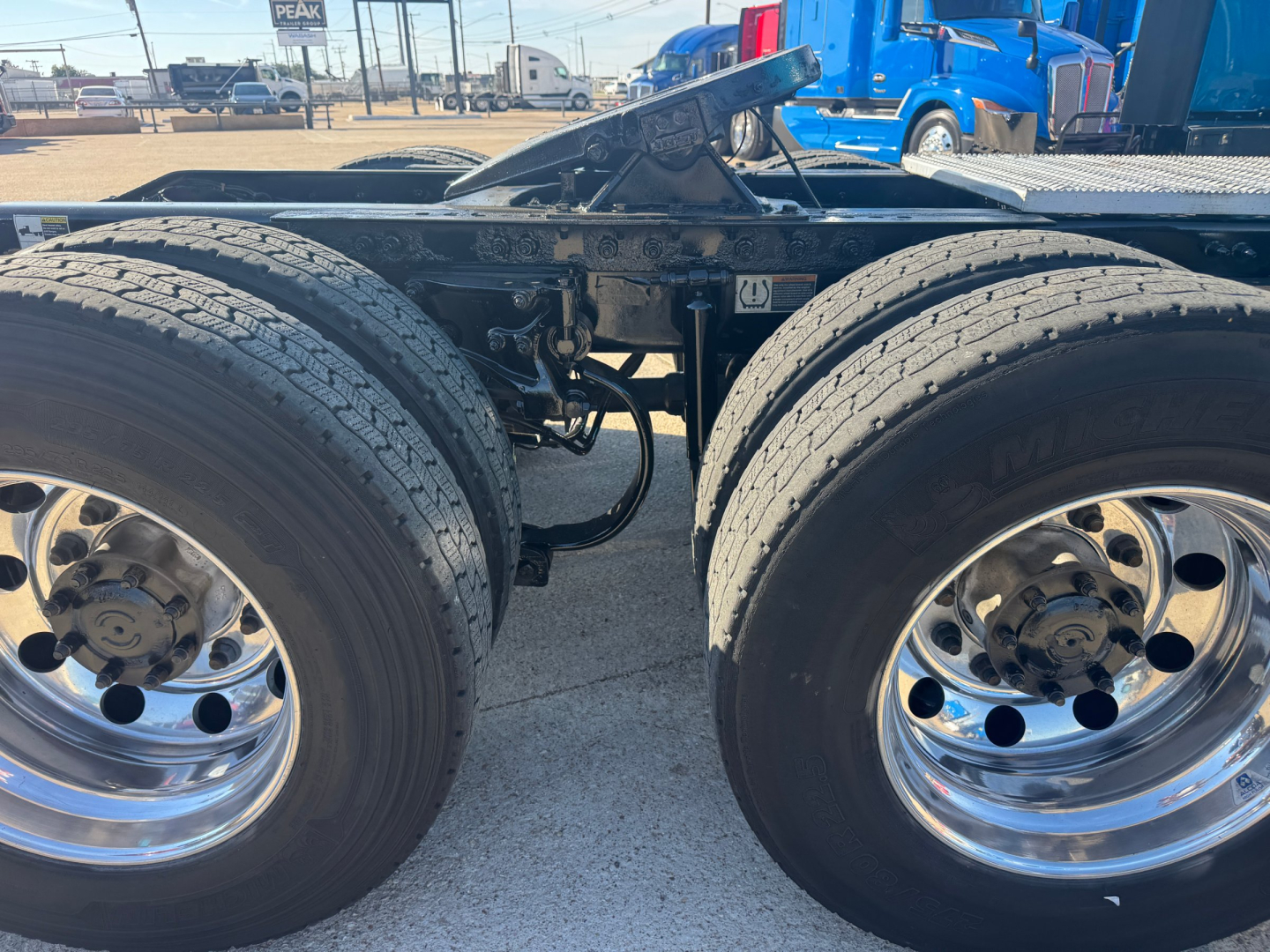 Peterbilt 579 chassis focusing on dual rear axles and wheel assemblies showing polished steel wheels and tires with chassis frame in view.